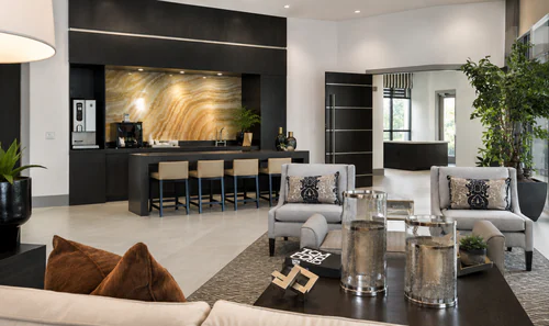 Resident coffee bar with barstools and a stone backsplash at The Mayfair Apartments