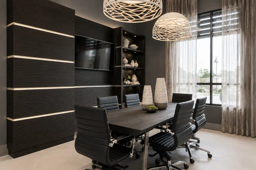 Conference room with a wall mounted television and seating for six at The Mayfair Apartments