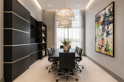 Conference room with a long table, task chairs, and natural light at The Mayfair Apartments