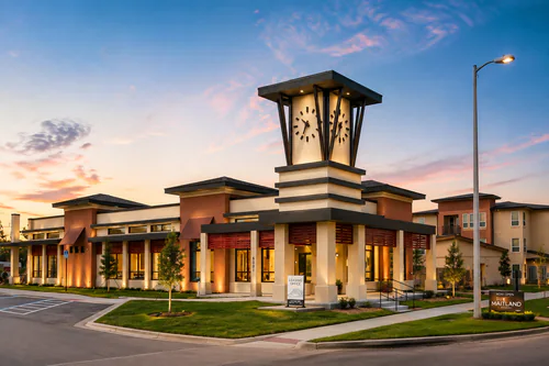Clubhouse exterior with a lighted clock tower at dusk