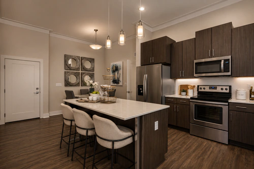 Kitchen with a quartz island, dark cabinetry, and an eat in dining area at The Mayfair Apartments