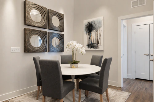 Dining area with a round table and framed mirrors in a Mayfair apartment home